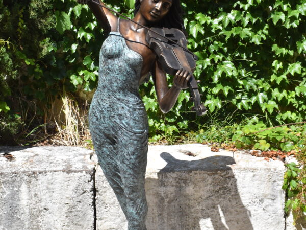 a large bronze statue of a woman playing a violin
