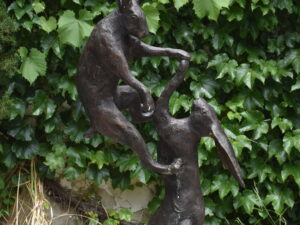 a bronze sculpture of boxing hares