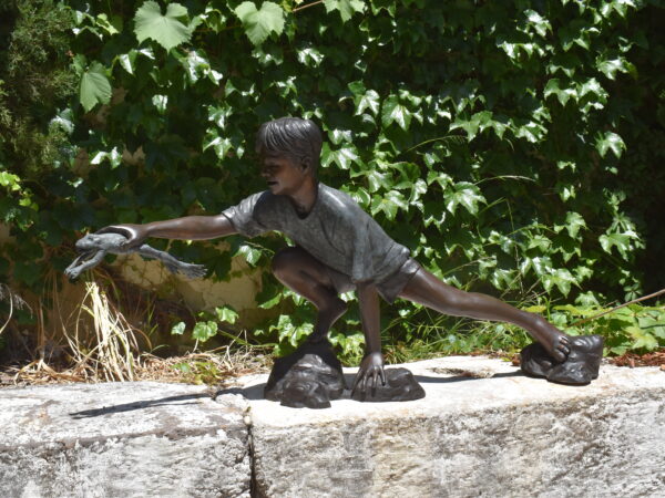 A bronze boy holding a frog, plumbed as a fountain.