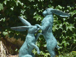 a bronze sculpture of boxing hares