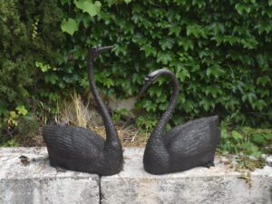a pair of bronze swans plumbed as fountains.