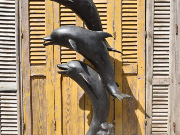 A bronze sculpture of 3 dolphins, plumbed as a fountain. 