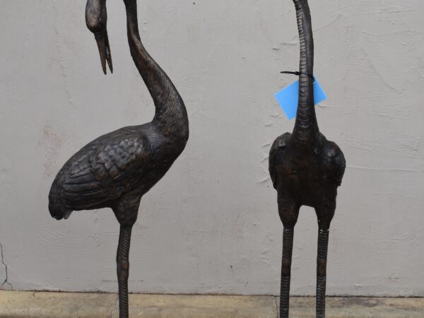 a pair of bronze cranes, plumbed as fountains. 