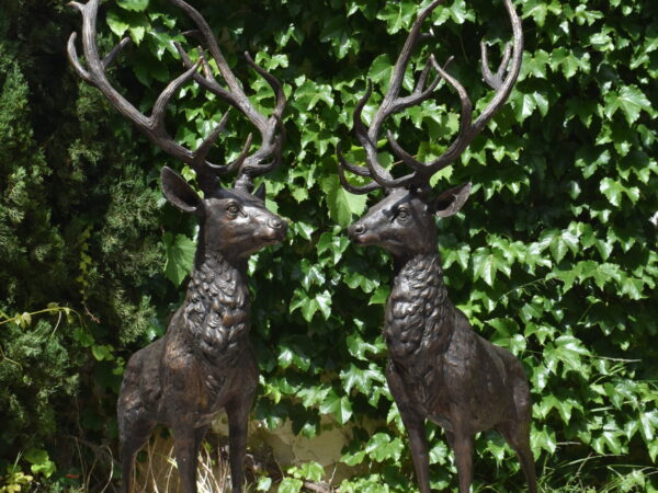 A pair of left and right facing bronze Stags on platform bases