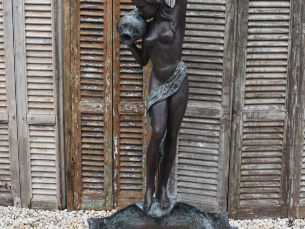 A bronze fountain featuring a maiden with an ewer, water issues from the ewer into the fountain bowl