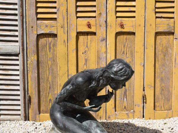 A bronze statue of a girl holding an ewer, plumbed as a fountain