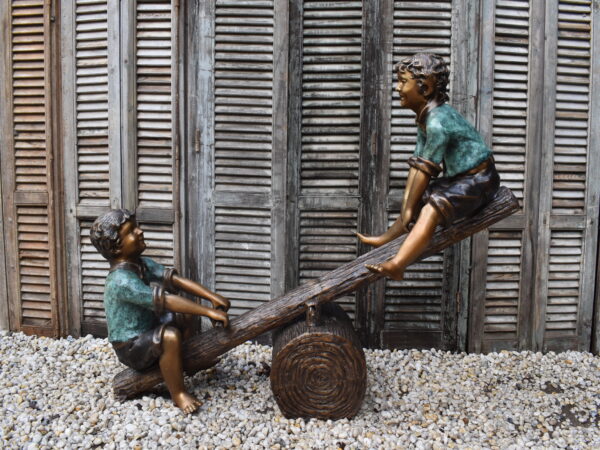 A wonderful bronze sculpture of two children on a see saw