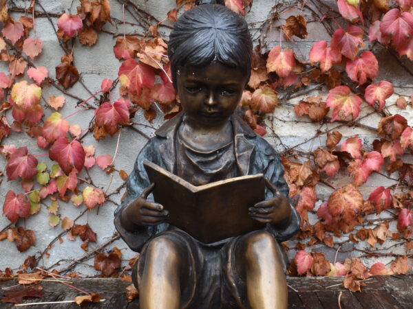 A wonderful bronze statue of a young girl reading