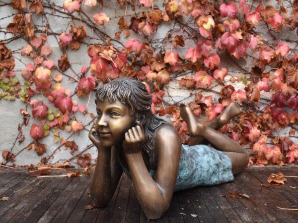 A fine bronze statue of a child contemplating